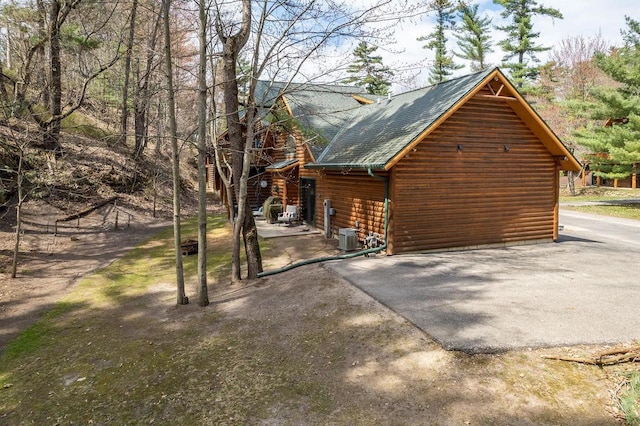 view of side of property with a shingled roof and central air condition unit