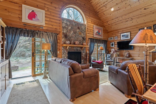 living area with high vaulted ceiling, a fireplace, log walls, and wood finished floors