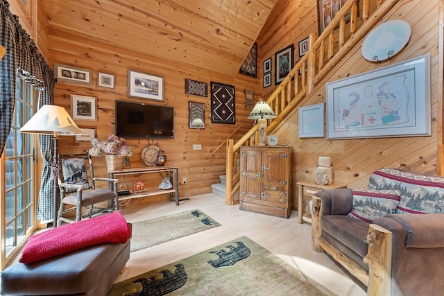 living room featuring wooden walls, wood ceiling, stairway, and wood finished floors