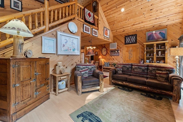 living area featuring a chandelier, high vaulted ceiling, wood walls, and wood finished floors