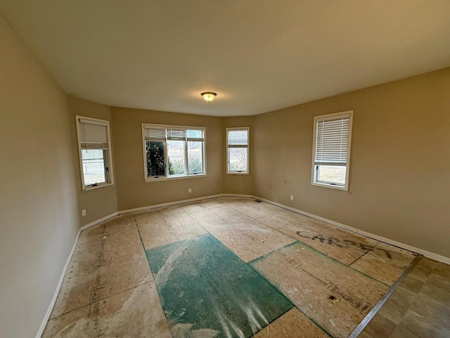 unfurnished room featuring baseboards