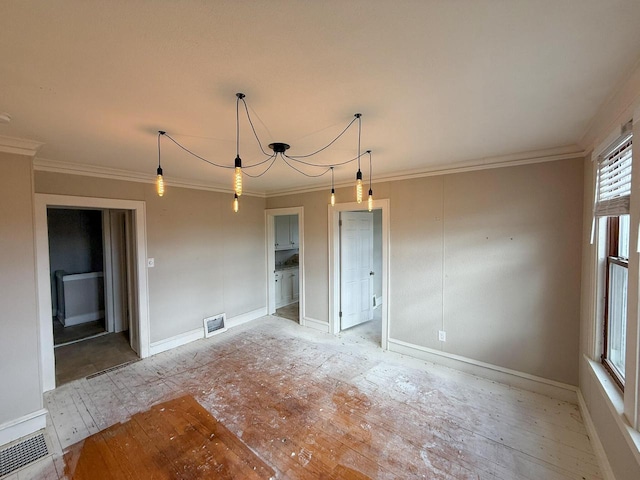 spare room featuring ornamental molding, visible vents, and baseboards