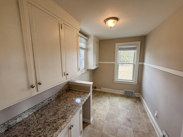 laundry area with visible vents and baseboards