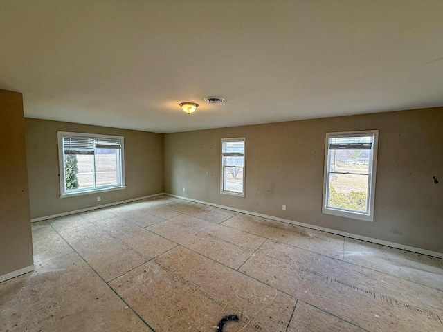 spare room featuring baseboards and visible vents