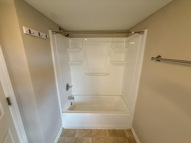 bathroom with shower / bathing tub combination and baseboards