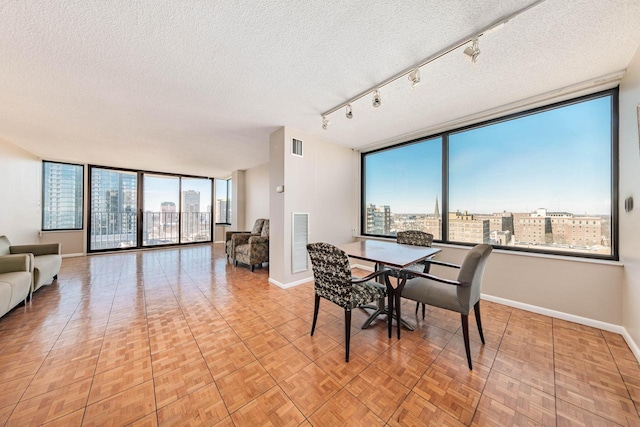 dining area with visible vents, a city view, and a textured ceiling