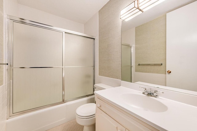 bathroom featuring toilet, tile patterned floors, combined bath / shower with glass door, and vanity