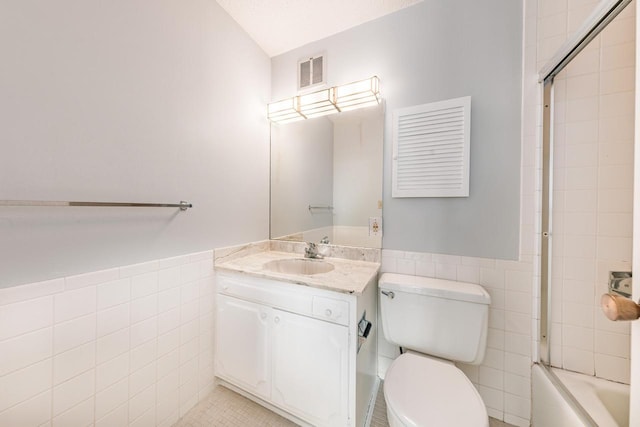 full bathroom featuring visible vents, toilet, a wainscoted wall, vanity, and tile walls