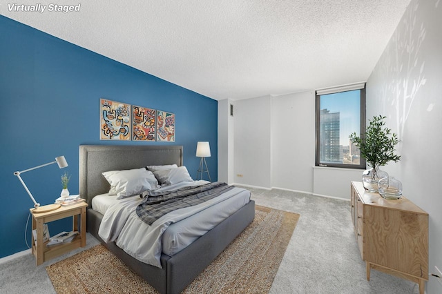 carpeted bedroom featuring a textured ceiling and baseboards