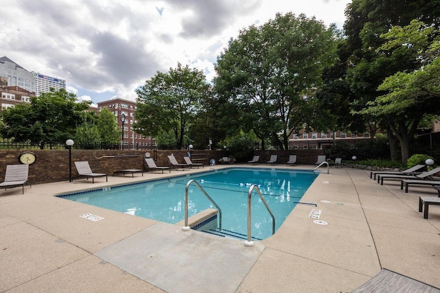 pool with fence and a patio