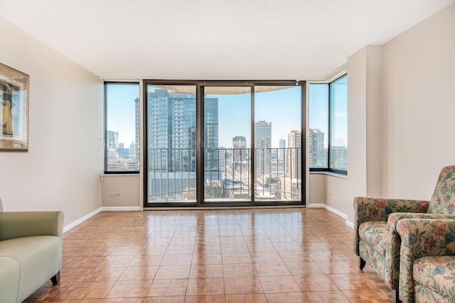 living area featuring a view of city, a textured ceiling, and baseboards