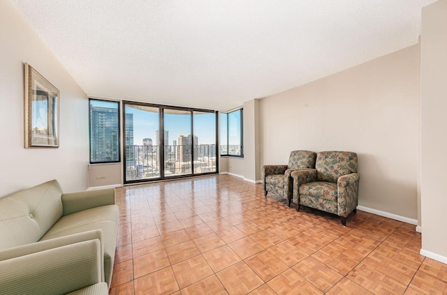 living room with a view of city, floor to ceiling windows, a textured ceiling, and baseboards