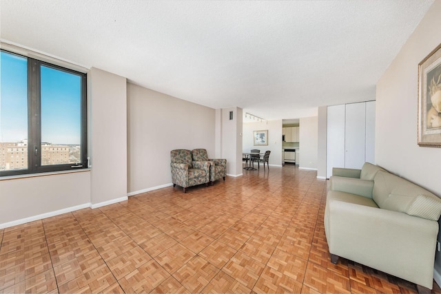 interior space featuring a textured ceiling and baseboards