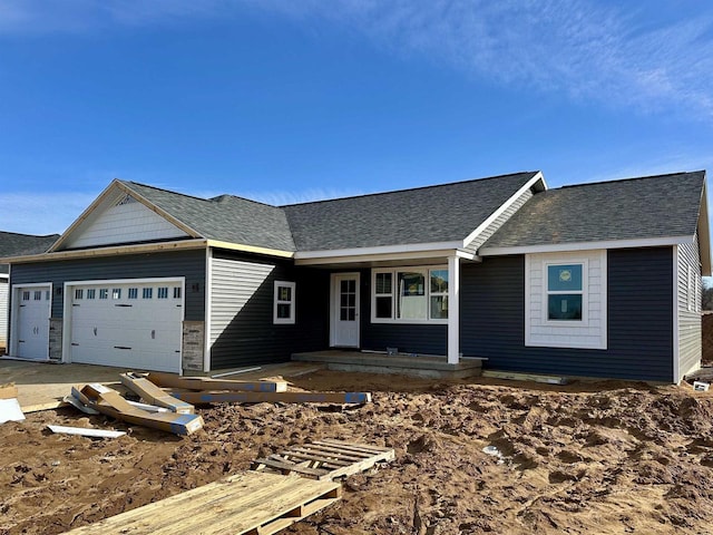 single story home featuring a garage and a shingled roof