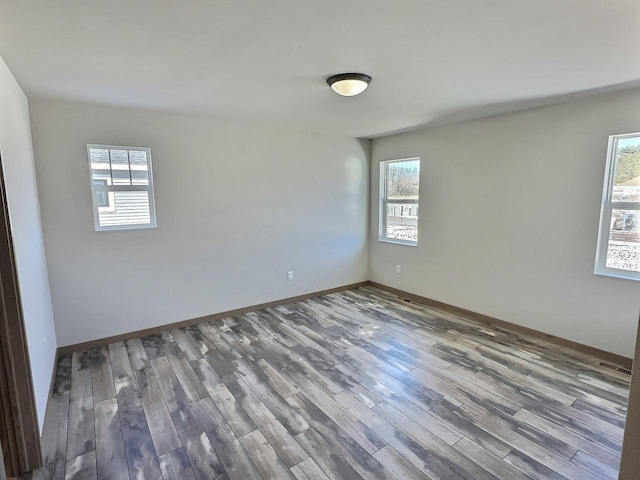 empty room with baseboards and wood finished floors