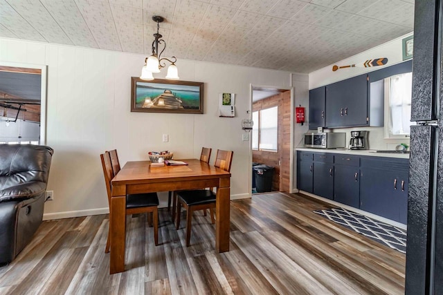 dining space featuring dark wood-style floors, a wealth of natural light, and baseboards