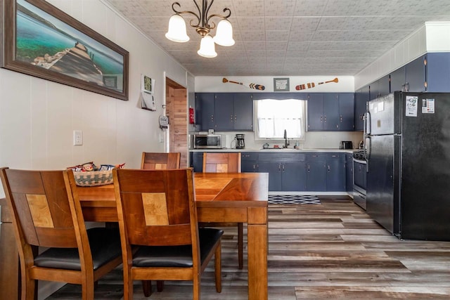 kitchen with range, dark wood finished floors, stainless steel microwave, freestanding refrigerator, and blue cabinets