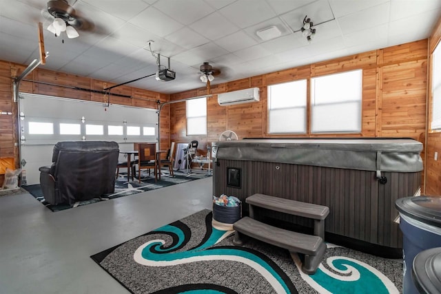 garage featuring ceiling fan, wooden walls, a wall mounted air conditioner, and a garage door opener