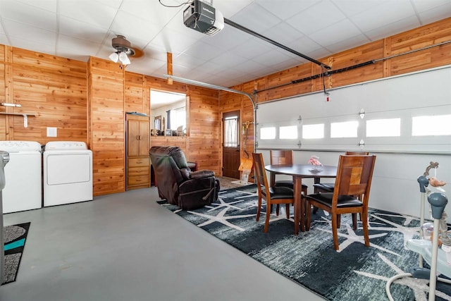 dining area with concrete flooring, wooden walls, and washing machine and clothes dryer