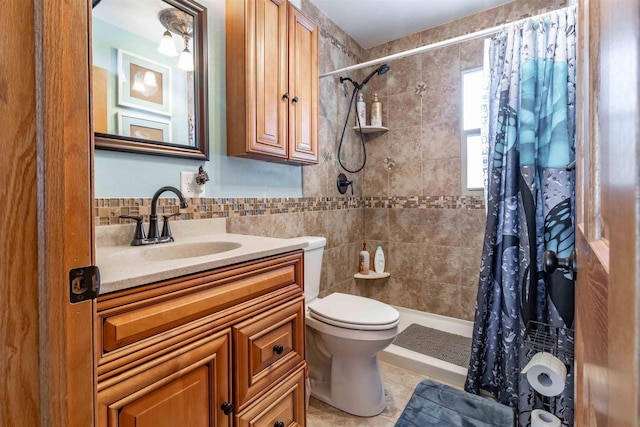 full bathroom featuring toilet, tile patterned flooring, a tile shower, and vanity