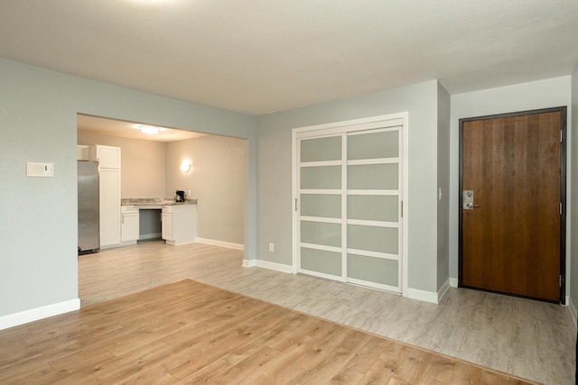 spare room with light wood finished floors and baseboards