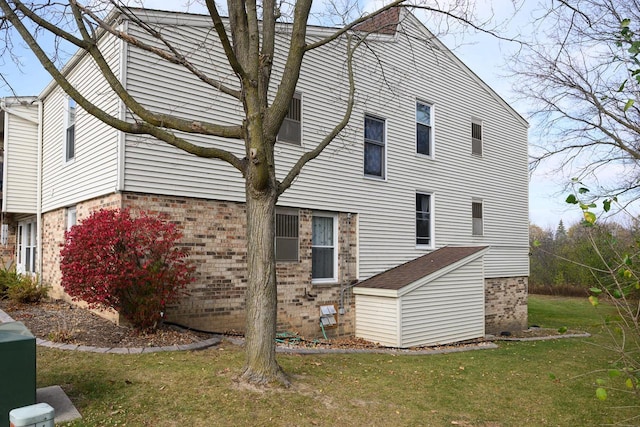 view of side of home with brick siding and a lawn