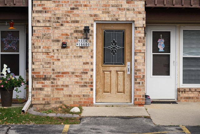 doorway to property featuring brick siding