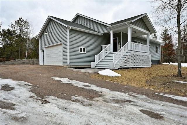 ranch-style home with driveway, an attached garage, and a porch