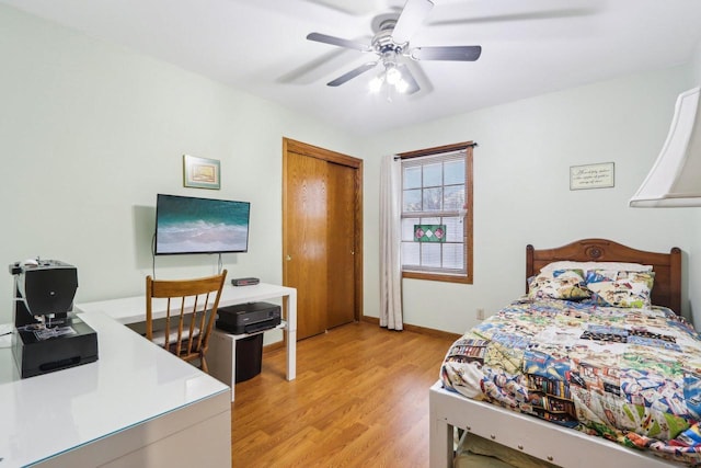 bedroom with a closet, light wood-type flooring, a ceiling fan, and baseboards