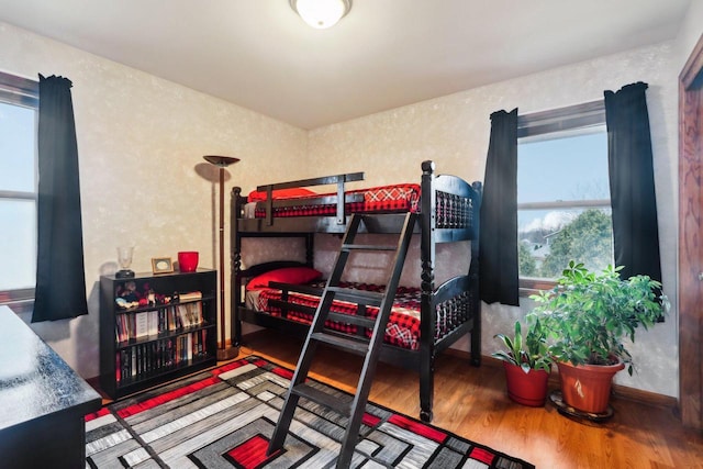 bedroom featuring multiple windows and wood finished floors