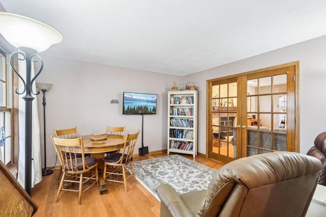 dining space featuring baseboards, wood finished floors, and french doors