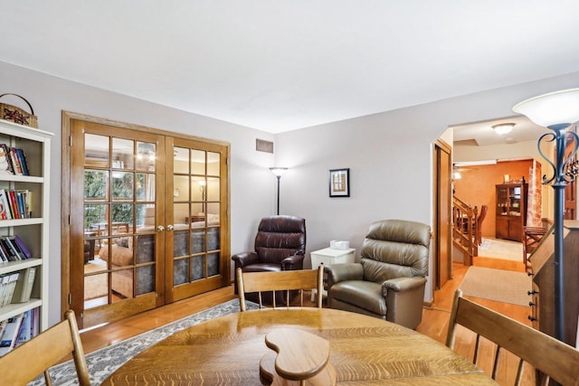 interior space featuring french doors, stairway, wood finished floors, and visible vents