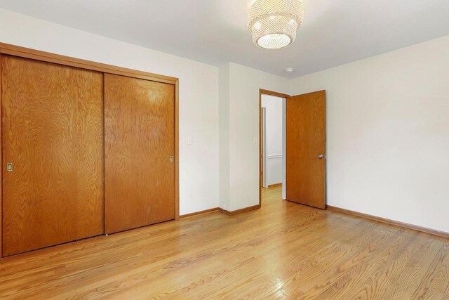 442 Forest Dr, Fontana, WI 53125 - unfurnished bedroom with light wood-type flooring, baseboards, and a closet