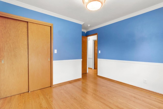 442 Forest Dr, Fontana, WI 53125 - unfurnished bedroom featuring wood finished floors, baseboards, ornamental molding, and a closet