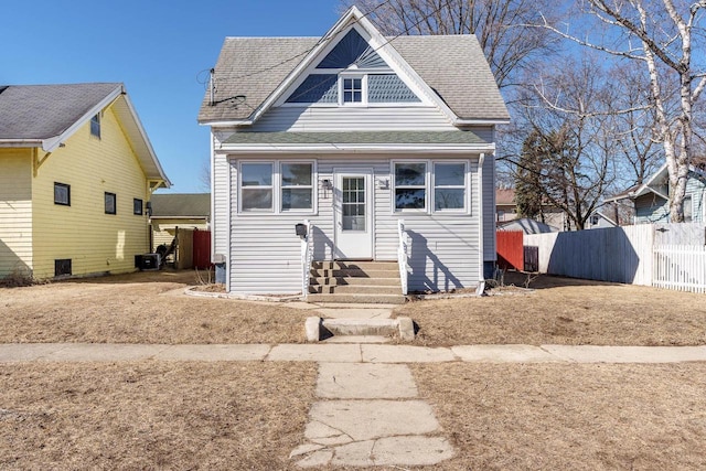 view of front of property featuring entry steps, roof with shingles, and fence