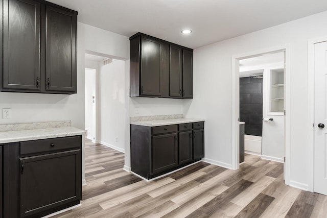 kitchen with light wood-style floors, baseboards, light countertops, and recessed lighting