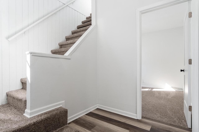 stairway with wood finished floors and baseboards