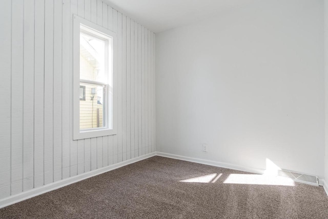 carpeted empty room featuring visible vents and baseboards