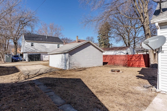 rear view of property featuring fence and an outbuilding