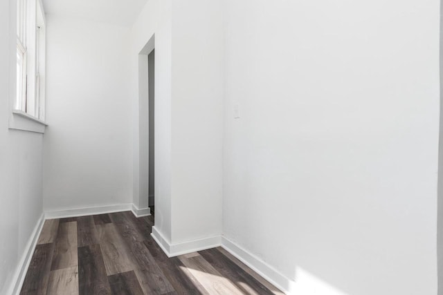 hallway with dark wood-type flooring and baseboards