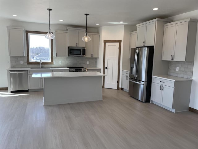 kitchen featuring a sink, light countertops, light wood-style floors, and stainless steel appliances