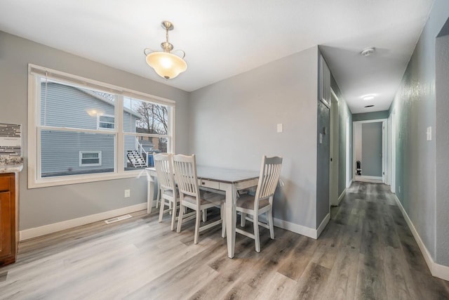 dining room with visible vents, light wood-style flooring, and baseboards