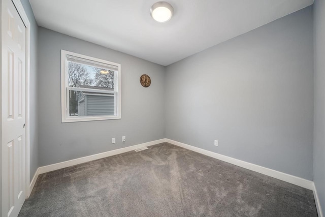 carpeted spare room featuring baseboards