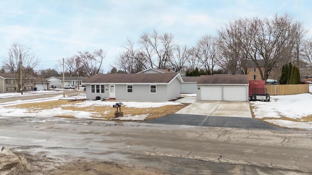 ranch-style home with a garage, fence, and an outbuilding