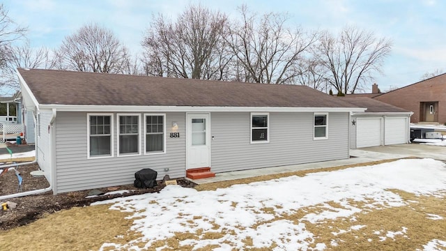 ranch-style house with entry steps, driveway, a shingled roof, and a garage