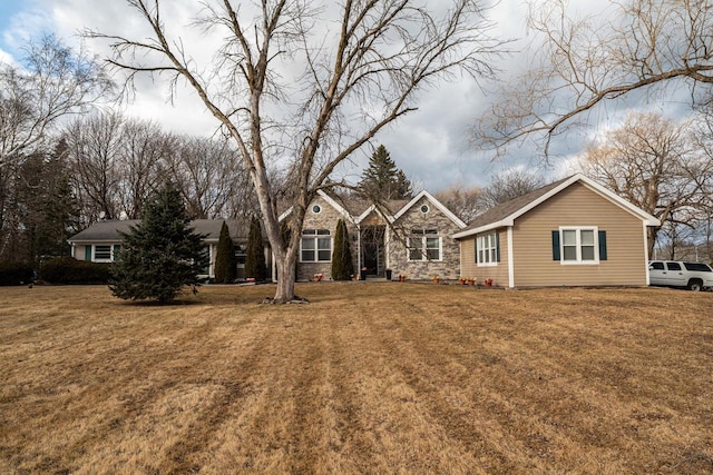 view of front facade with a front yard and stone siding