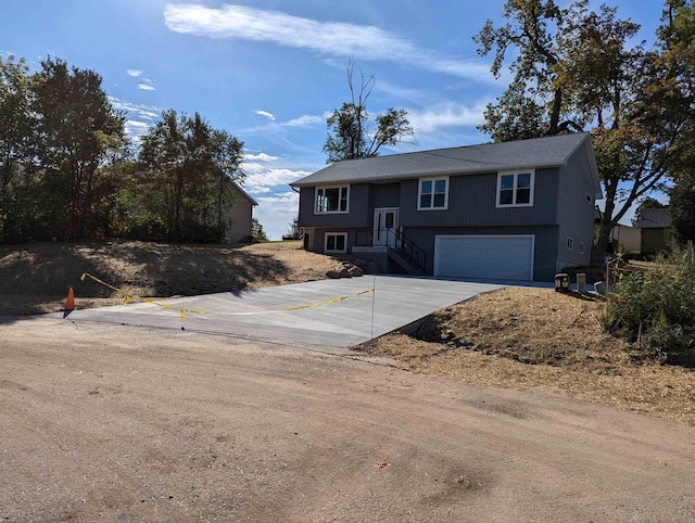 raised ranch featuring a garage and driveway