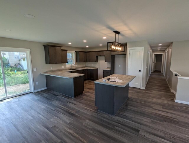 E11617 Pen-Marc Ct, Baraboo, WI 53913 - kitchen with dark wood-style flooring, a sink, a peninsula, and dark brown cabinets