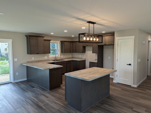 E11617 Pen-Marc Ct, Baraboo, WI 53913 - kitchen with dark wood-type flooring, a sink, a peninsula, and dark brown cabinets