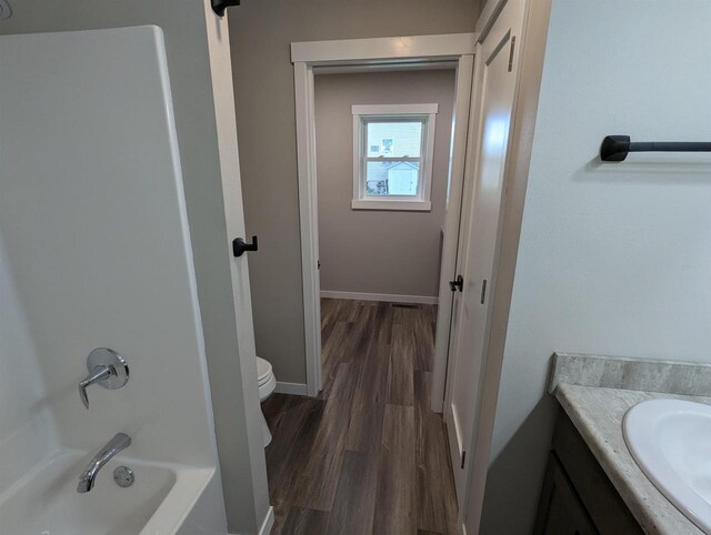 E11617 Pen-Marc Ct, Baraboo, WI 53913 - bathroom with toilet, shower / bath combination, wood finished floors, vanity, and baseboards